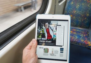 Melbourne, Australia - Feb 26, 2016: Reading digital magazine on an iPad onboard a train during commuting